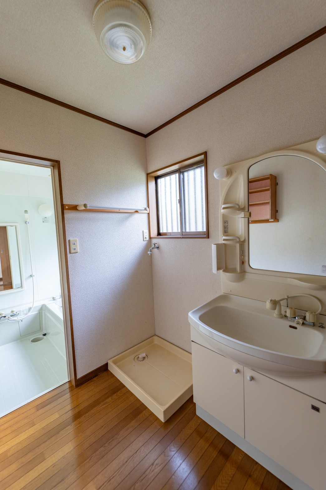 洗面・脱衣スペース。 室内洗濯機置き場と洗面台も設置有り。小さな収納棚も壁に設置されています。